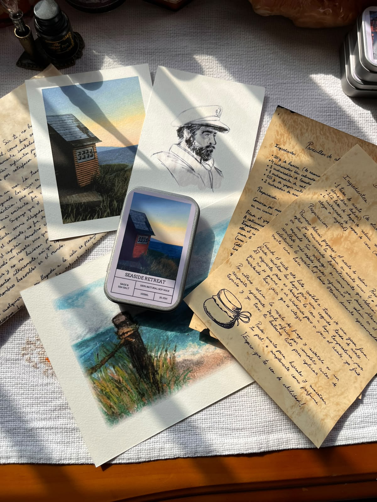 pack experiencia inmersivo seaside retreat que incluye vela aromática de salvia y sal marina, carta de un personaje ficticio, ilustraciones hechas a mano y recetas.